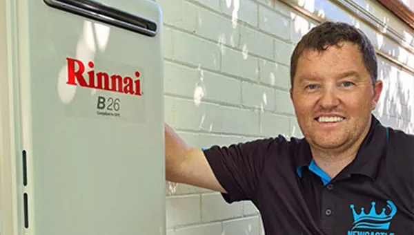 Plumber finishing a continuous-flow gas hot water install